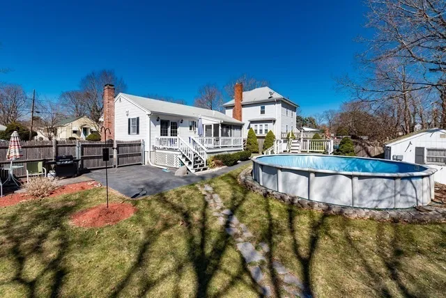 a view of a house with pool and chairs
