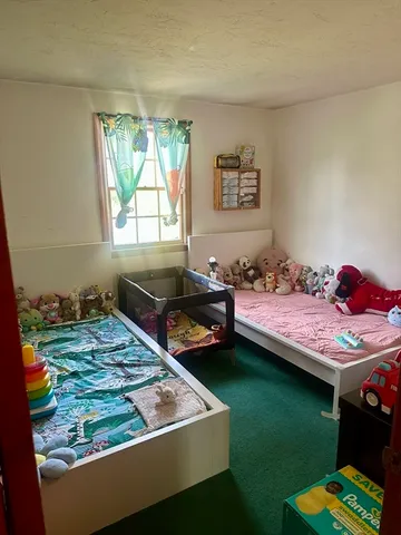 a bed sitting in a bedroom next to a window
