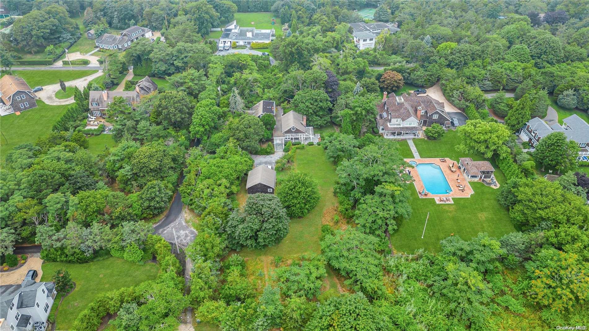 an aerial view of residential house with outdoor space and trees all around