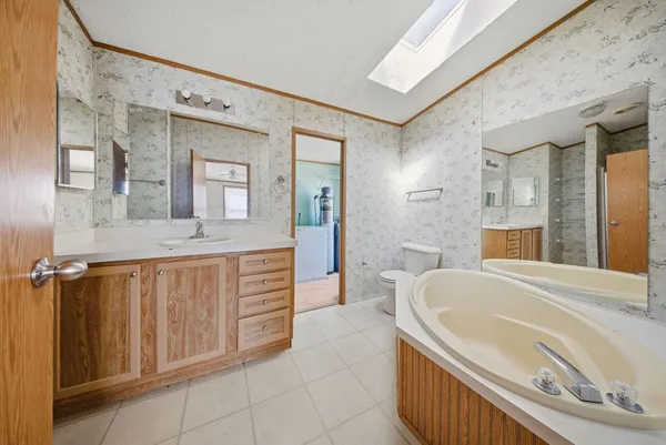 a spacious bathroom with a tub sink and mirror