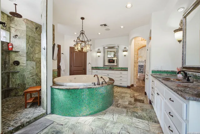 a spacious bathroom with a tub sink and mirror