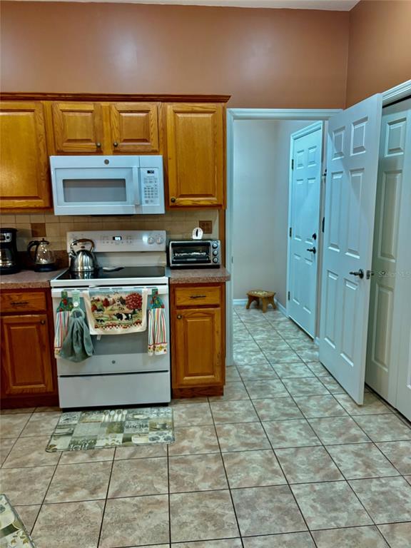 18970 Southwest 99th Street Dunnellon, FL 34432 - Photo 22 of 52 a kitchen with stainless steel appliances granite countertop a stove a sink and a refrigerator