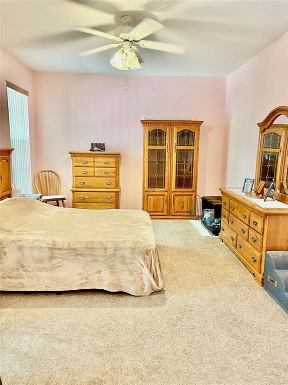 18970 Southwest 99th Street Dunnellon, FL 34432 - Photo 6 of 52 a bedroom with a bed and a chandelier