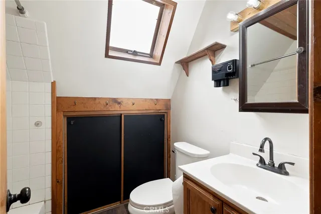 a bathroom with a toilet a sink and mirror