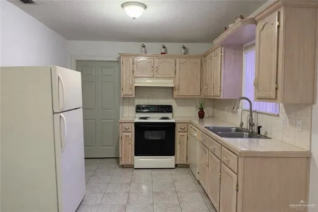 a kitchen with a refrigerator sink and cabinets