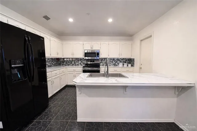 a kitchen with kitchen island a sink stainless steel appliances and cabinets