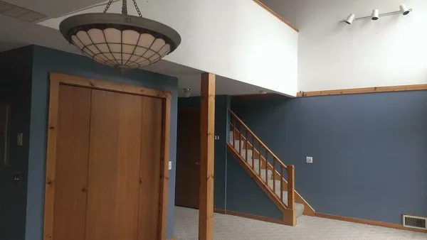 a view of staircase with railing and white walls