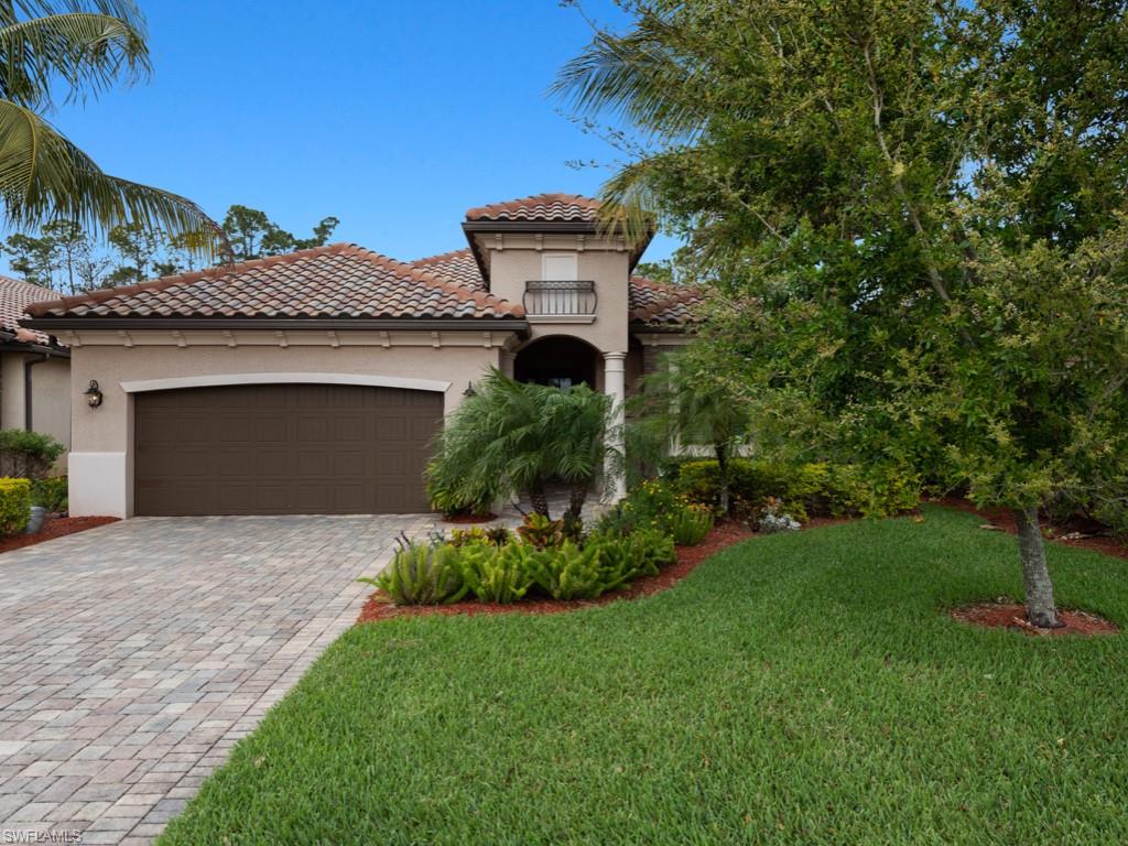 9507 Piacere Way Naples, FL 34113 - Photo 1 of 32 a front view of a house with a garden and yard