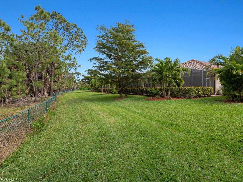 9507 Piacere Way Naples, FL 34113 - Photo 23 of 32 a view of a garden with a building in the background