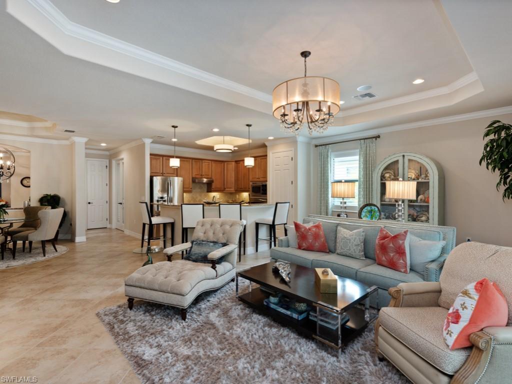 9507 Piacere Way Naples, FL 34113 - Photo 3 of 32 a living room with furniture a chandelier and a dining table