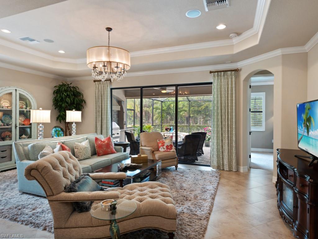 9507 Piacere Way Naples, FL 34113 - Photo 4 of 32 a living room with furniture chandelier and a flat screen tv