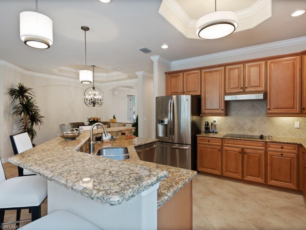 9507 Piacere Way Naples, FL 34113 - Photo 9 of 32 a kitchen with stainless steel appliances granite countertop a sink refrigerator and cabinets