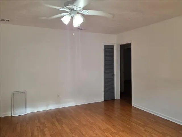a view of an empty room with wooden floor