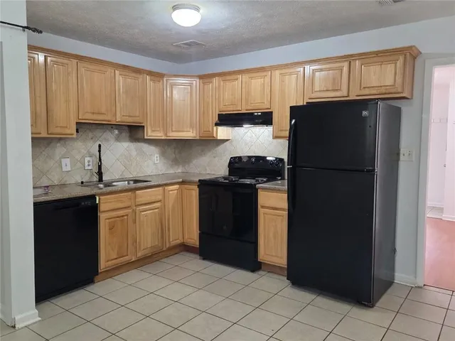 a kitchen with a refrigerator and a sink