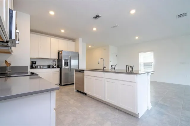 a kitchen with white cabinets and stainless steel appliances