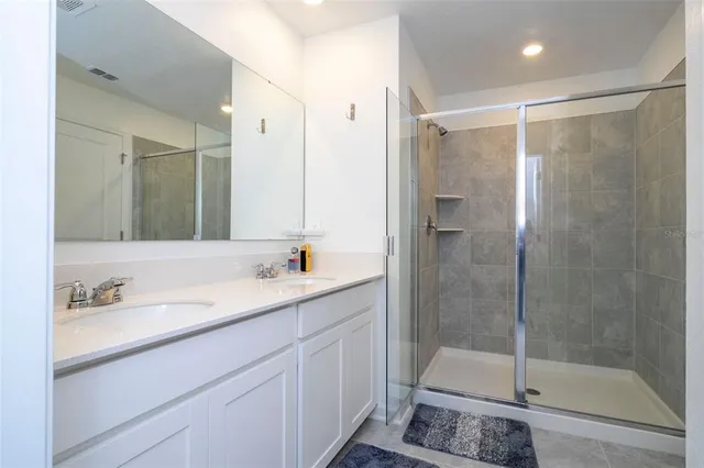 a bathroom with a shower sink and mirror