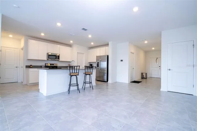 a view of kitchen with refrigerator stove microwave and cabinets