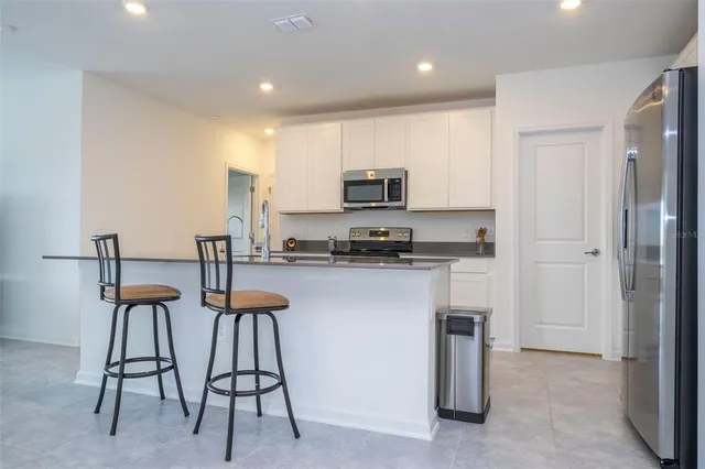 a kitchen with furniture a refrigerator and a stove top oven