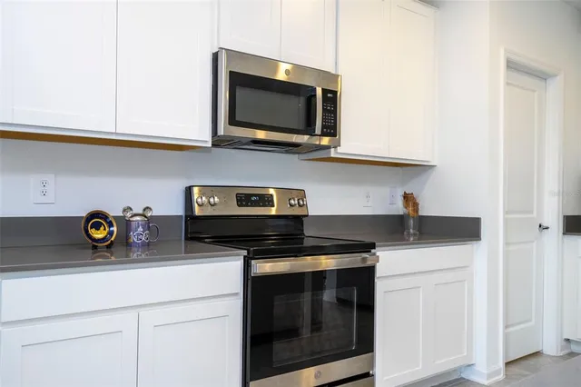 a kitchen with stainless steel appliances granite countertop a sink a stove and microwave