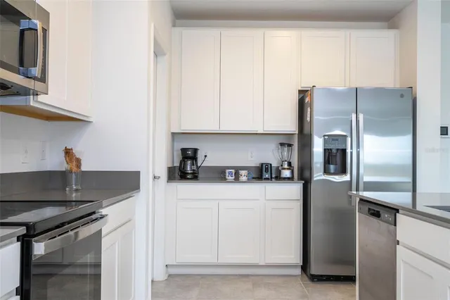 a kitchen with stainless steel appliances granite countertop a refrigerator a stove and a sink with wooden floor