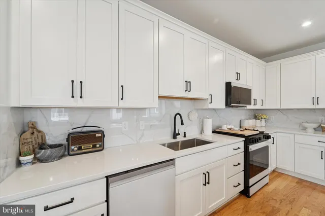 a kitchen with stainless steel appliances a stove a sink a microwave a refrigerator and cabinets