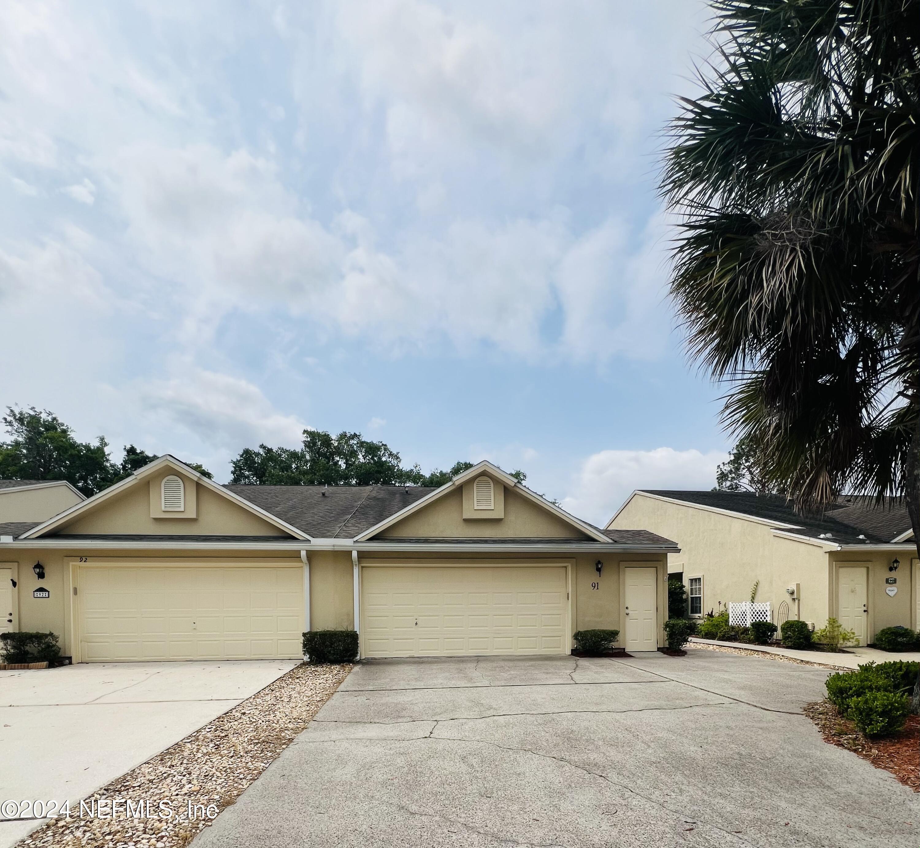 91 Fox Valley Drive Orange Park, FL 32073 - Photo 2 of 28 a front view of a house with a garden and trees