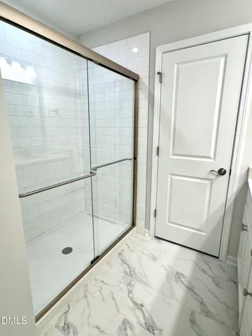 a spacious bathroom with a double vanity sink a mirror and a shower