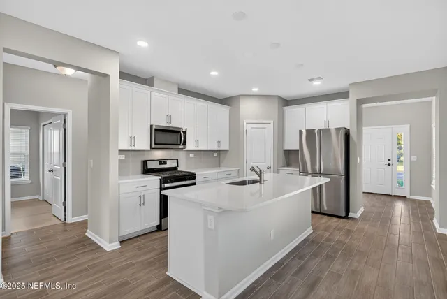 a kitchen with stainless steel appliances a refrigerator and a stove
