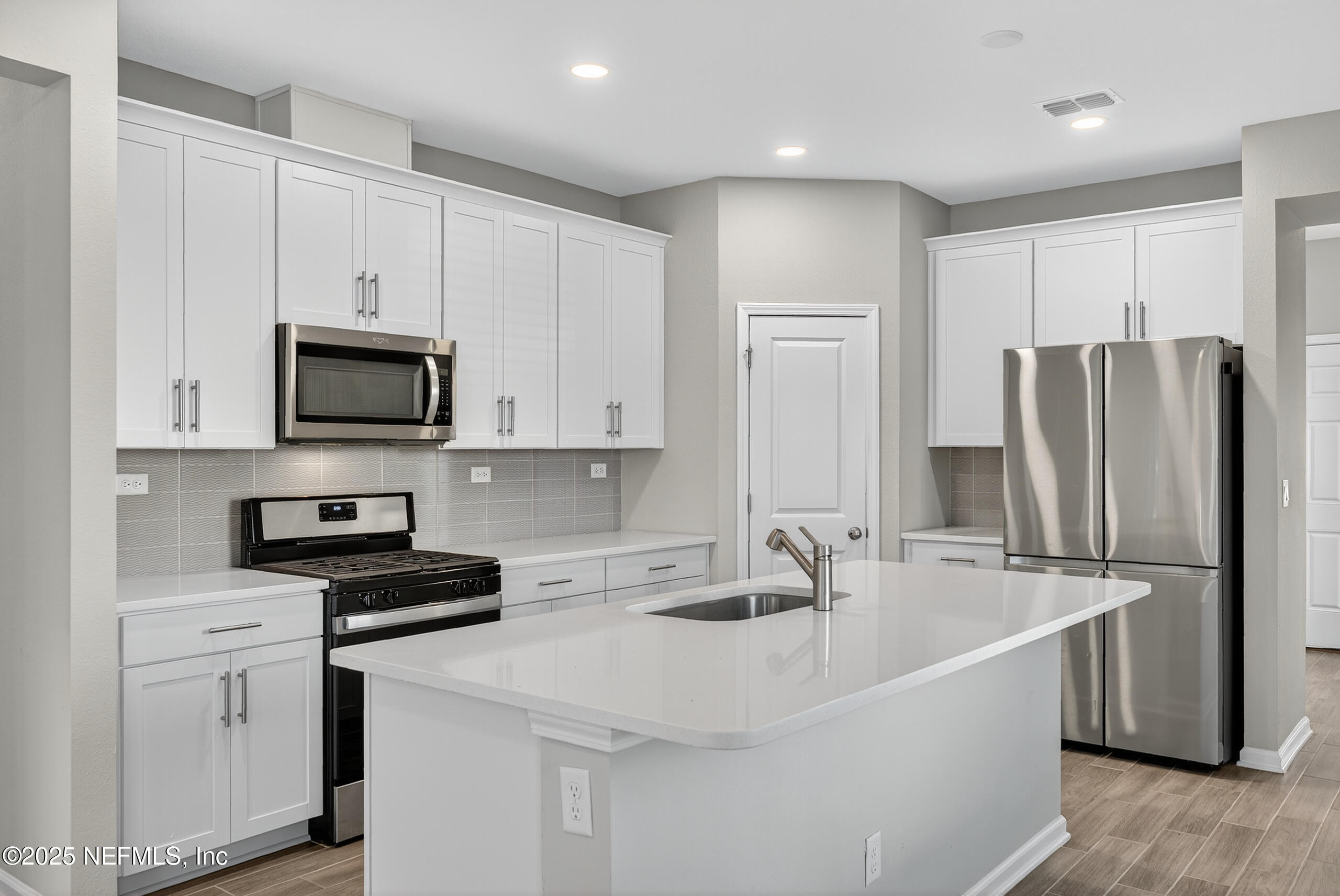 75598 Blackbird Drive Yulee, FL 32097 - Photo 12 of 30 a kitchen with stainless steel appliances a refrigerator stove microwave and sink