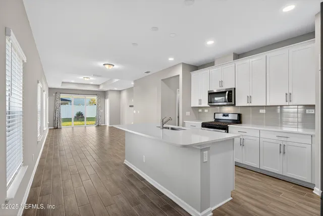 a kitchen with stainless steel appliances a stove microwave and refrigerator