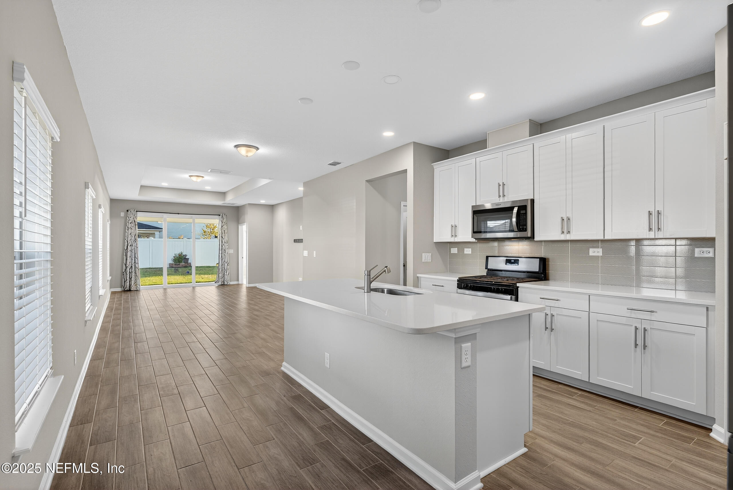 75598 Blackbird Drive Yulee, FL 32097 - Photo 8 of 30 a kitchen with kitchen island white cabinets and stainless steel appliances