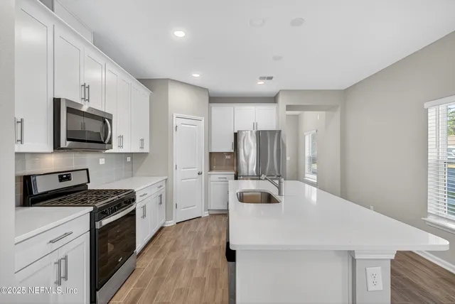 a kitchen with stainless steel appliances a refrigerator stove microwave and sink