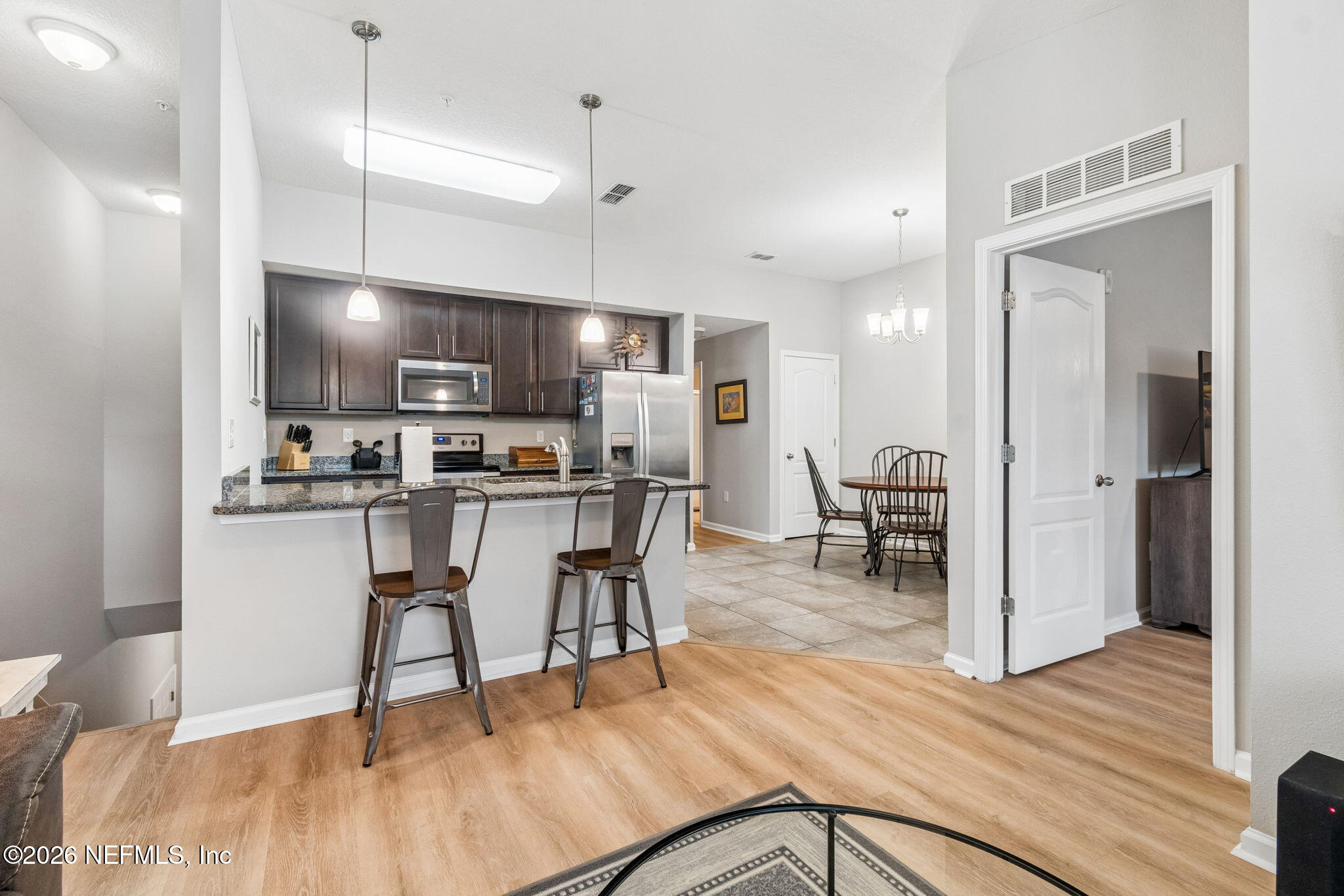 2113 Golden Lake Loop St. Augustine, FL 32084 - Photo 10 of 50 a kitchen with stainless steel appliances a dining table chairs and wooden floor