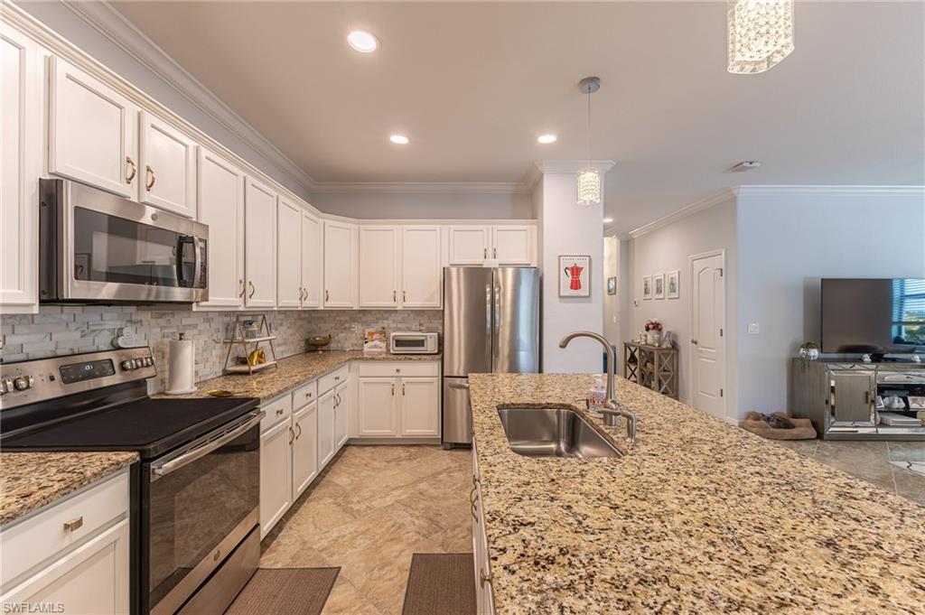 9231 Shadow Oak Lane Naples, FL 34120 - Photo 17 of 46 a kitchen with stainless steel appliances granite countertop a stove top oven a sink dishwasher a refrigerator and cabinets with wooden floor