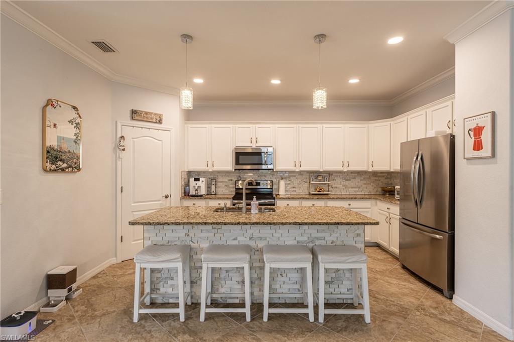 9231 Shadow Oak Lane Naples, FL 34120 - Photo 18 of 46 a kitchen with kitchen island cabinets and refrigerator
