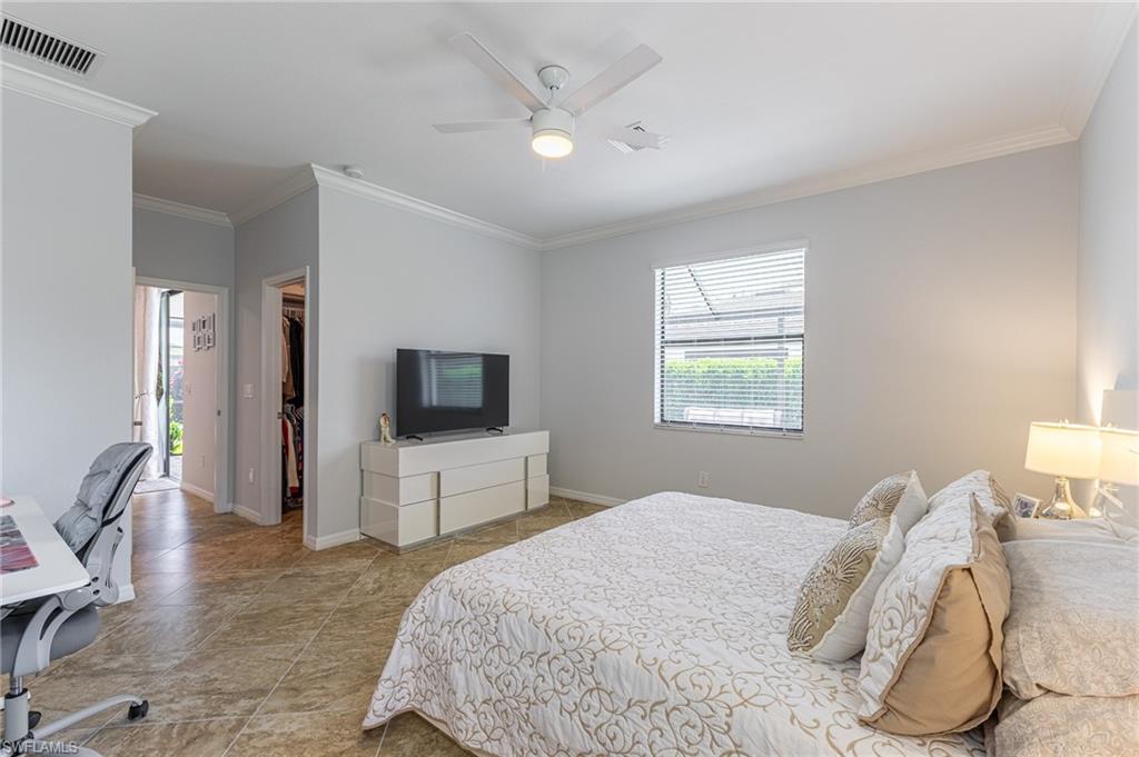 9231 Shadow Oak Lane Naples, FL 34120 - Photo 24 of 46 a bedroom with a large bed and a flat screen tv