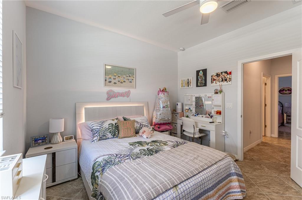 9231 Shadow Oak Lane Naples, FL 34120 - Photo 31 of 46 a bedroom with a bed and a chandelier