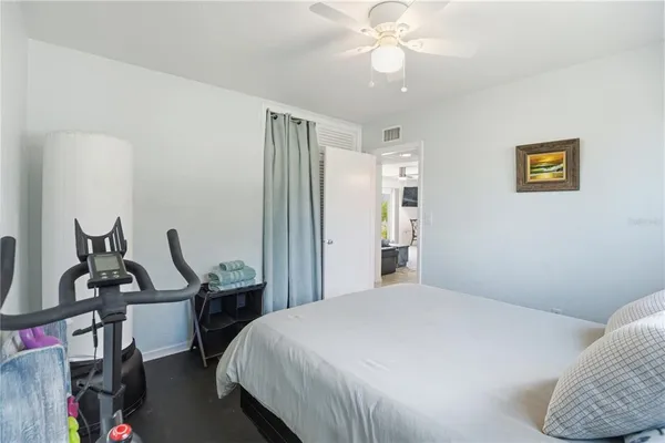 a bedroom with a bed a dresser with wooden floor