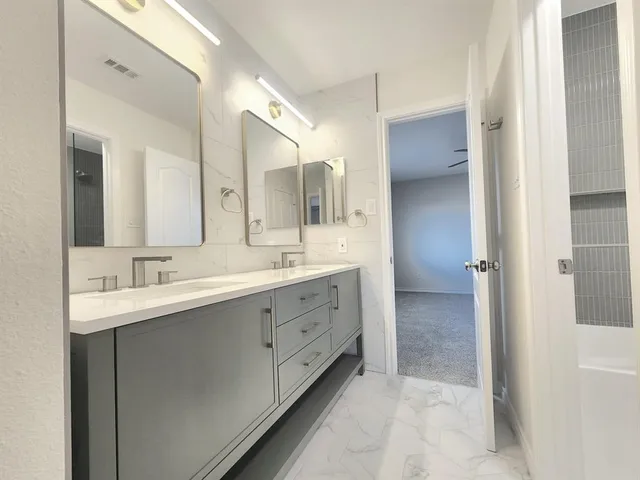 a spacious bathroom with a double vanity sink mirror and double