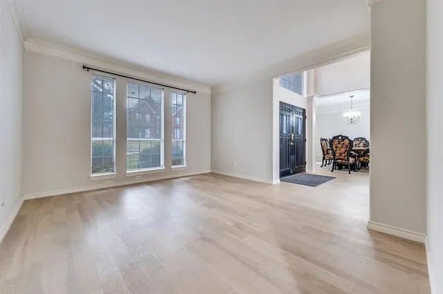 a view of a livingroom with wooden floor and a large window