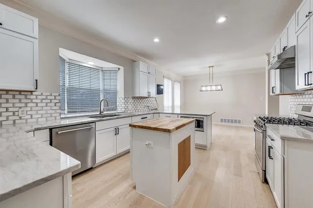 a kitchen with stainless steel appliances granite countertop a sink stove and refrigerator