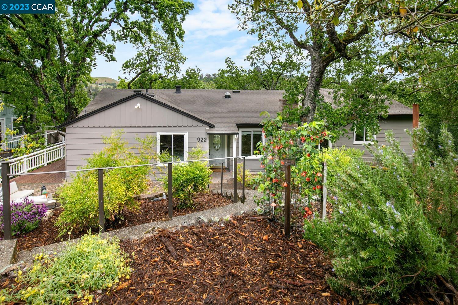 a yellow house with flower garden in front of it