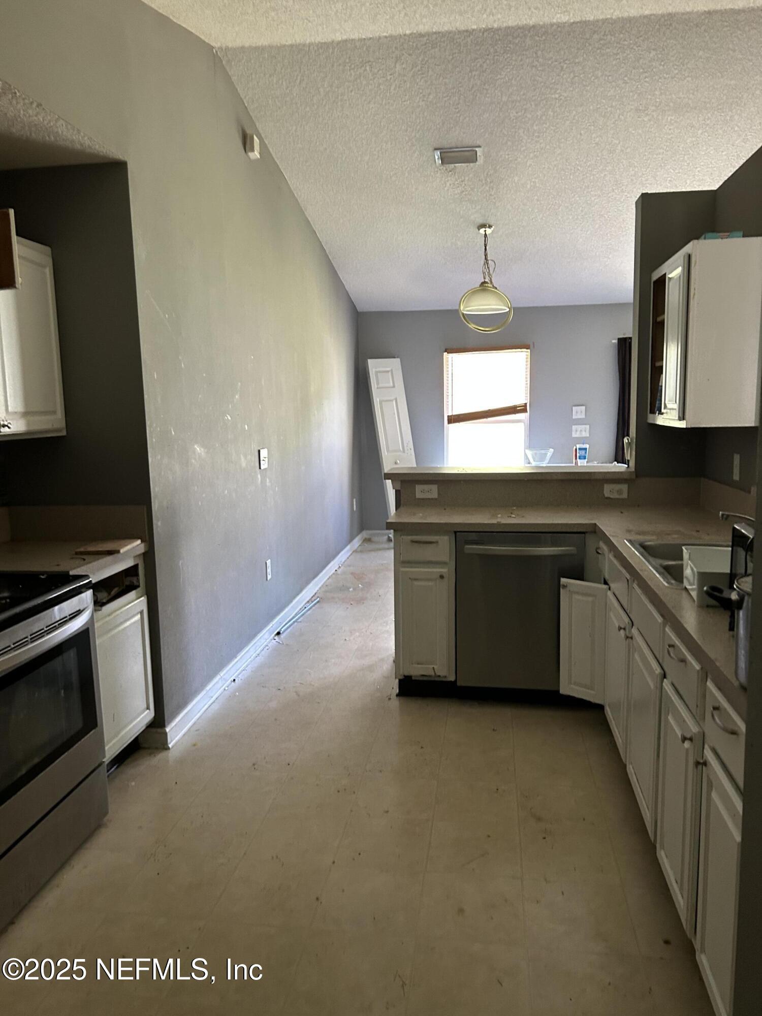 6369 Spring Hollow Court Jacksonville, FL 32218 - Photo 8 of 20 a kitchen with stainless steel appliances granite countertop a sink a stove top oven a counter space and cabinets