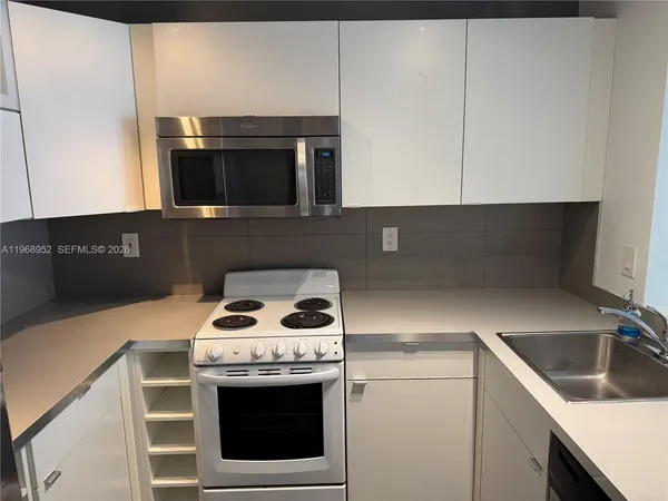 a kitchen with a sink and a stove top oven