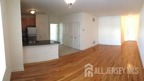 a view of empty room with wooden floor