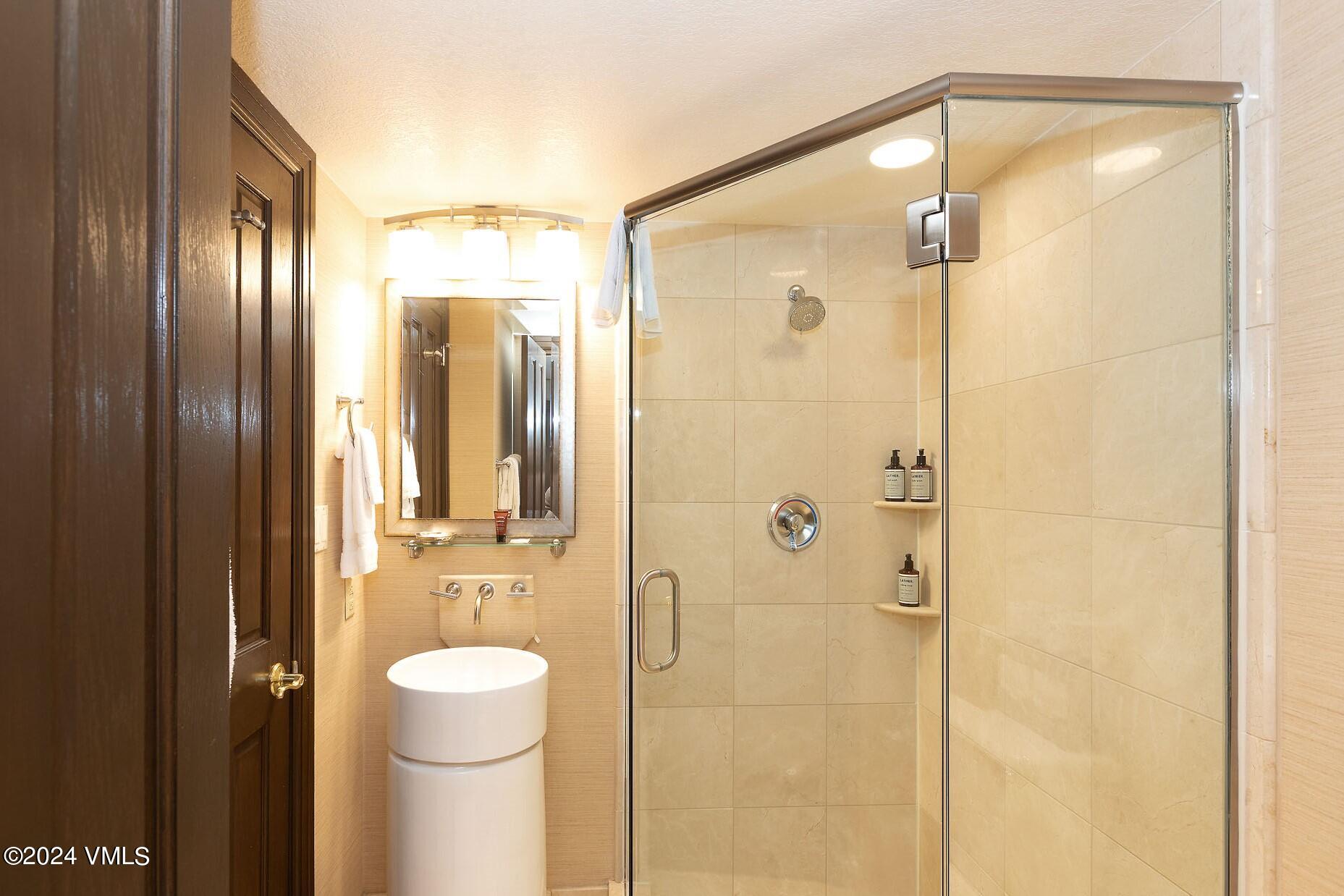 210 Offerson Road, Unit R215 WEEK 47 Beaver Creek, CO 81620 - Photo 11 of 26 a bathroom with a shower a sink and a mirror