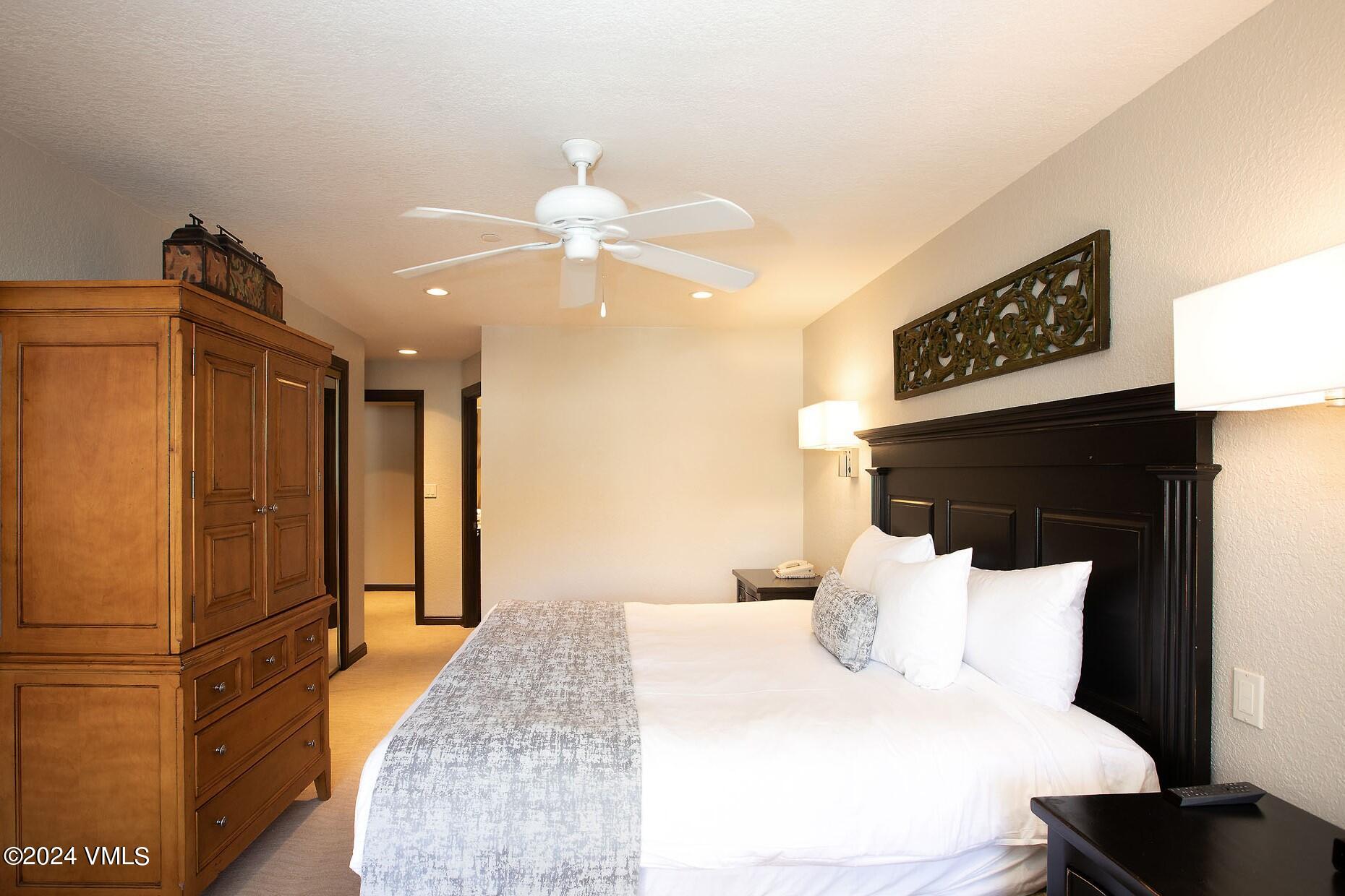 210 Offerson Road, Unit R215 WEEK 47 Beaver Creek, CO 81620 - Photo 22 of 26 a spacious bedroom with a bed and a chandelier