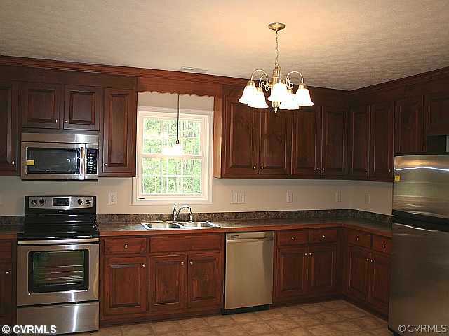 5 Winding Ridge Way Bumpass, VA 23024 - Photo 3 of 10 a kitchen with granite countertop stainless steel appliances a stove and a microwave