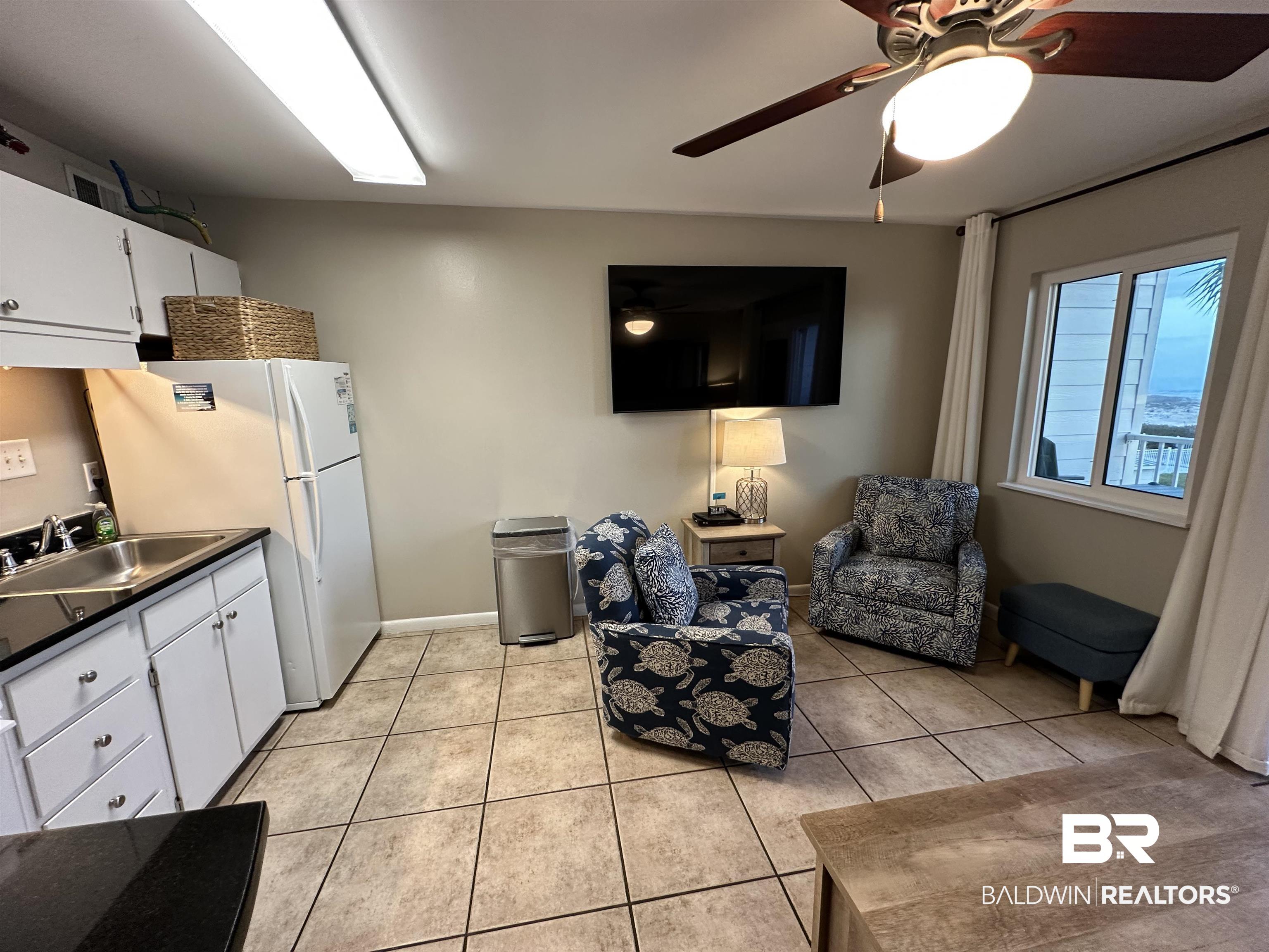 400 Plantation Road, Unit 2202 Gulf Shores, AL 36542 - Photo 25 of 26 Kitchen featuring white cabinetry, freestanding refrigerator, light tile patterned flooring, a ceiling fan, and dark countertops