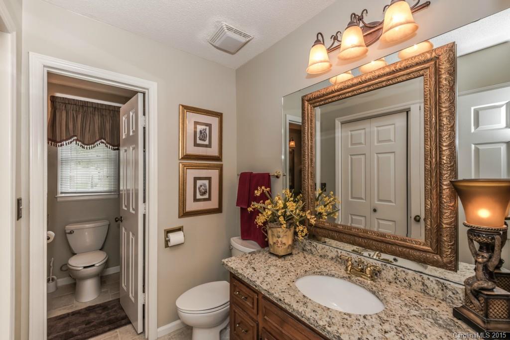 6737 Harrison Road Charlotte, NC 28270 - Photo 13 of 23 a bathroom with a granite countertop toilet a sink and a mirror